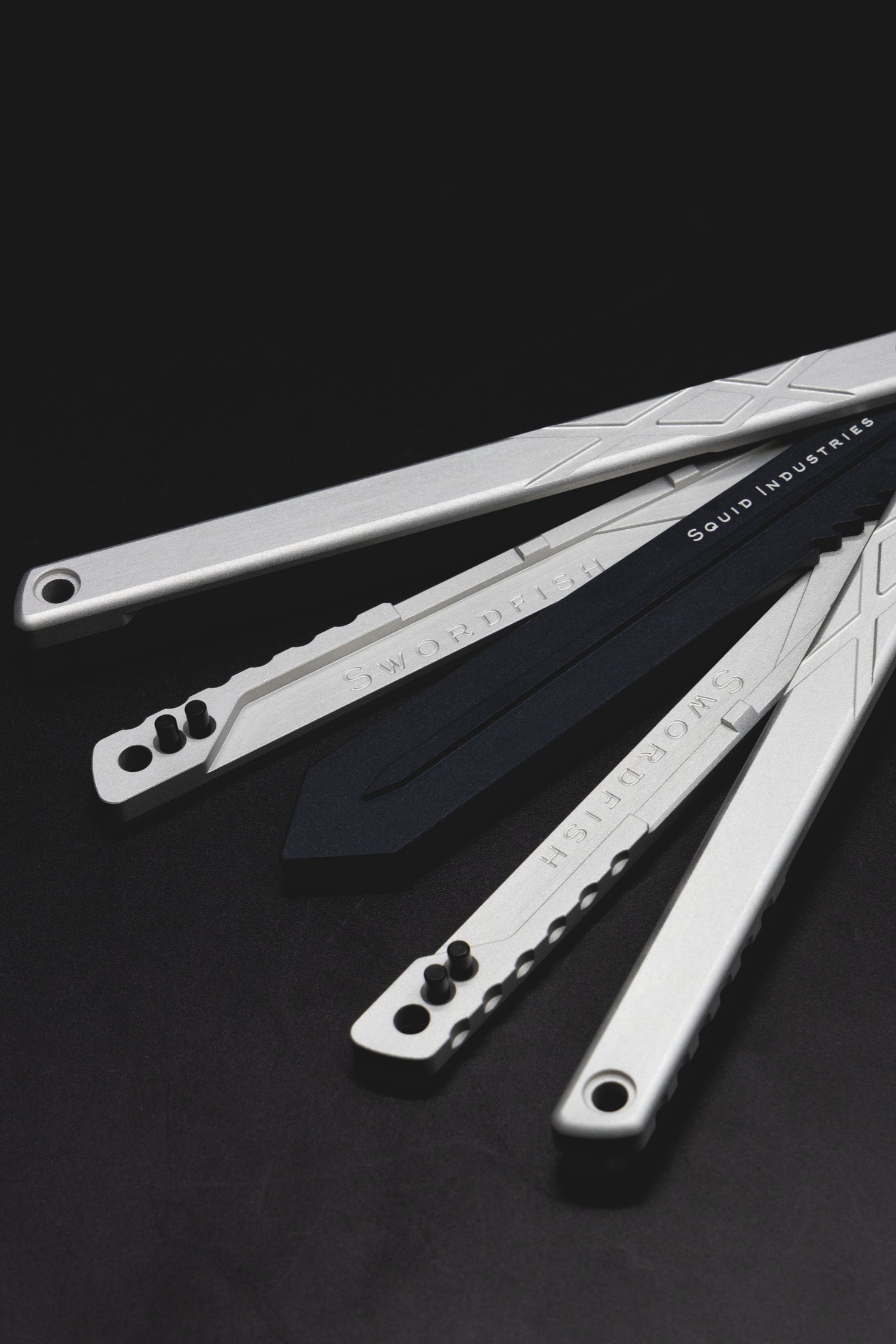 anatomy of the swordfish balisong trainer. black trainer blade, silver handles