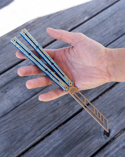hand holding a blue engraved damascus krake raken 