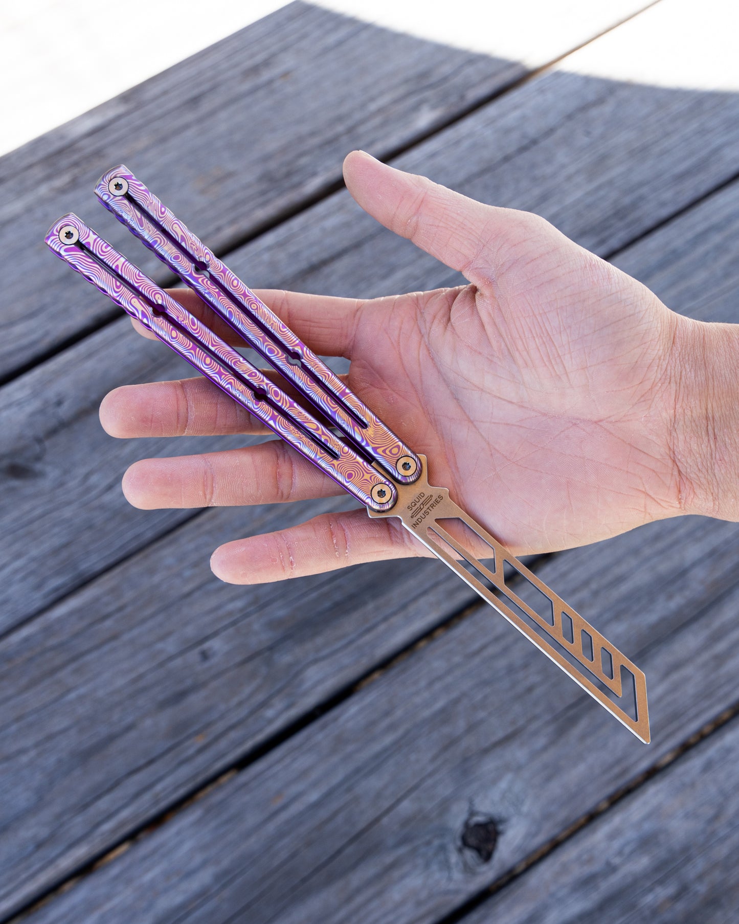 hand holding magenta engraved damascus titanium krake raken